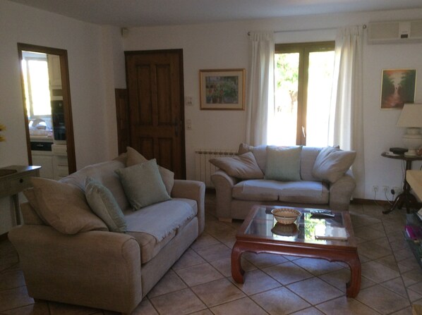 Ein Wohnzimmer mit zwei Sofas, einem Couchtisch und einer Tür.