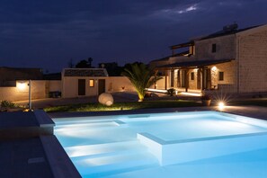 A swimming pool with steps leading into it, surrounded by a well-lit patio area with a house in the background. - Emotions of Casa Barone, villa with swimming pool, sea view, suitable for large groups (Scicli)