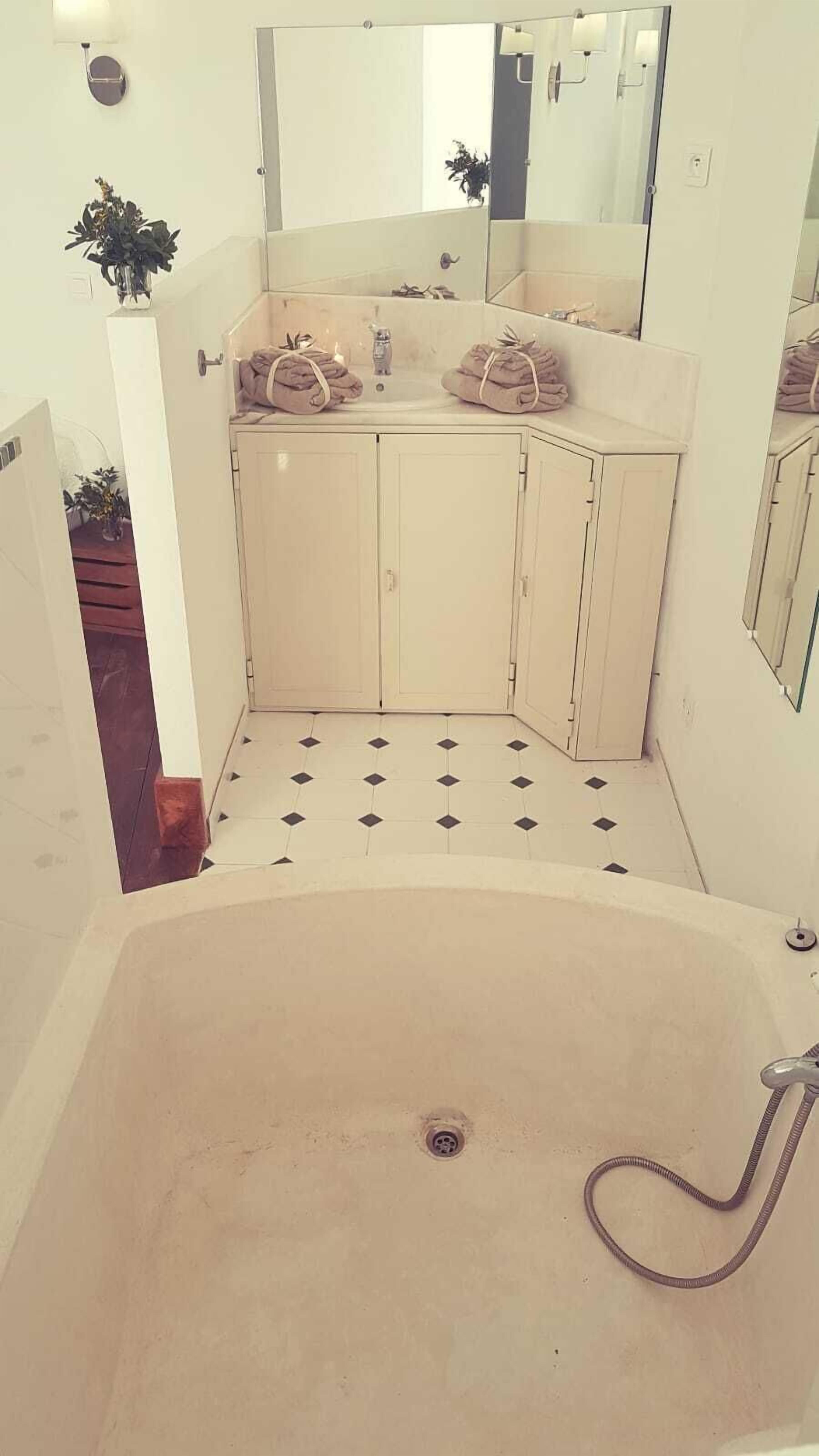 A bathroom with a bathtub, two sinks, and a mirror.