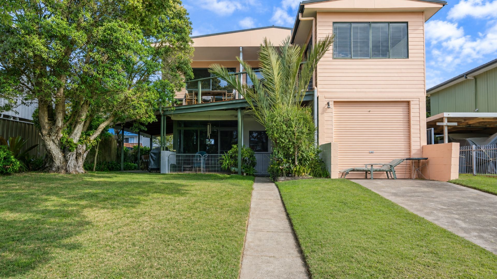 A two-story house with a covered patio and a garage.