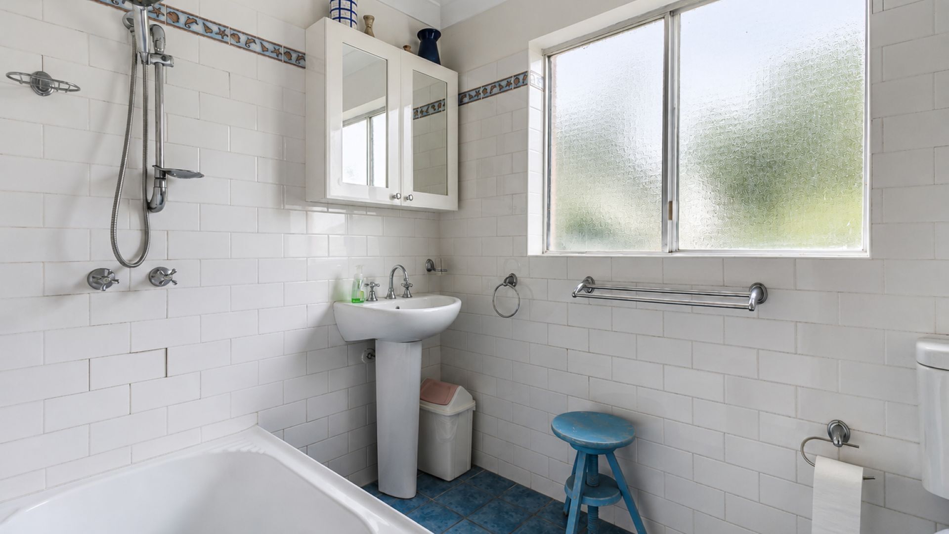 Un baño con bañera, lavabo y ventana.