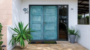 A teal double door with a number '59' above it, a potted plant to the left, and another to the right. - Waterfront Delight on Cater (Sussex Inlet)