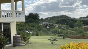A residential area with a house, a small garden, and a balcony. - Tranquil Falmouth Harbour View Villa (Piccadilly)