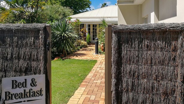 A gated entrance to a property with a sign indicating "Bed & Breakfast" and "vacancies". - Airport B&B (Redcliffe)