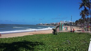 Una spiaggia con vista sull'oceano e sullo skyline urbano sullo sfondo.