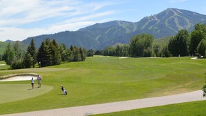 A golf course with a clear path, a sand bunker, and a mountainous backdrop. - Atelier Condo 1107 - Charming Condo with Access to Sun Valley Resort Pool (Sun Valley)