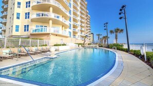 Un hotel con piscina, balcones y vistas al océano.