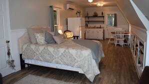 A bedroom with a bed, a chair, a desk, and a kitchenette. - Privacy, fishing, pool--Just 10 mins to beach/base (Sneads Ferry)