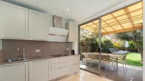 A modern kitchen with a built-in oven, a sink, and a dining area with a table and chairs. - LUXURY PROPERTY, PRIVATE HEATED POOL, FREE FIBER WIFI (Mogán)