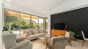 A modern living room with a sofa, armchairs, a coffee table, and a TV. - LUXURY PROPERTY, PRIVATE HEATED POOL, FREE FIBER WIFI (Mogán)