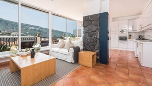 A modern living room with a sofa, coffee table, and a view of the mountains. - Ocean/volcano views, terrace, wifi, concierge [B] (Icod de los Vinos)