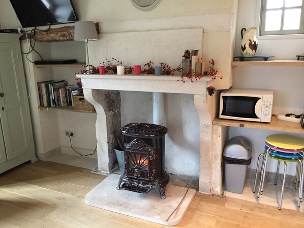 A kitchen with a fireplace, a microwave, and a stove.