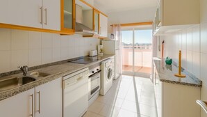 A modern kitchen with white cabinets, a granite countertop, and a built-in oven.