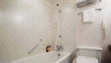 A bathroom with a bathtub, a toilet, a shower, and a towel rack with towels.