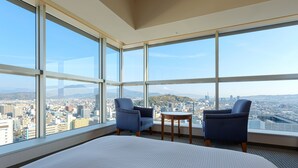 A hotel room with large windows, a bed, two chairs, and a small table. - Hotel Grand Hills Shizuoka (Shizuoka)