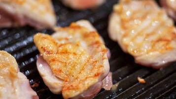Pechugas de pollo a la parrilla con queso derretido sobre una plancha.