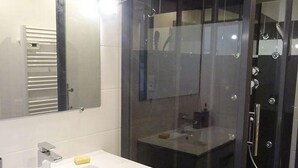 A modern bathroom with a glass-enclosed shower, a white vanity with a mirror, and a sink. - Appt T2 - : 3 stars *** : near beach, îles Madame, ile d'Aix (Saint Nazaire sur charente)