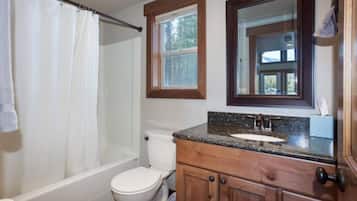 Een bad/douchecombinatie, een haardroger, handdoeken, zeep