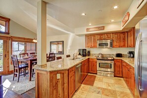 Enjoy cooking in this well-equipped kitchen with a granite countertop, stainless steel appliances, and ample counter space.