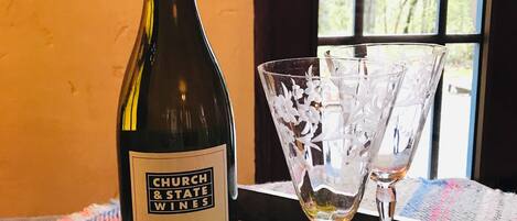 Una botella de vino Viognier Church & State Wines sobre una bandeja con dos copas de vino.
