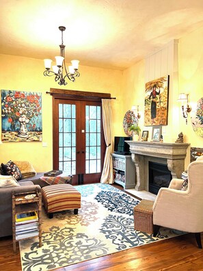 Télévision, cheminée, lecteur de DVD, livres