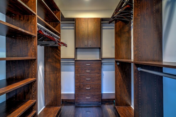 Ein begehbarer Kleiderschrank mit Holzböden, einer mittleren Doppeltür und einer Kleiderstange.