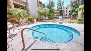 A swimming pool with a metal ladder, surrounded by a fence, and lounge chairs. - Best Pool in the Area!- Walk to Everything Old Town! -2 Private Master Suites (Scottsdale)