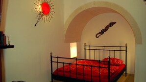 Ein Schlafzimmer mit einem Bett, einer Wandlampe und einem dekorativen Gegenstand.