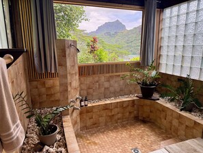 A bathroom with a view of a mountainous landscape, a shower area, and potted plants. - Beautiful Private Home with Stunning Views of Opunohu Bay (Opunohu Bay)