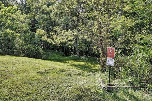 A hiking trail sign with a warning about ticks and thorns.