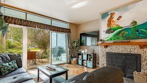 Ein Wohnzimmer mit Kamin, Fernseher und einem Wandgemälde einer Meerjungfrau.
