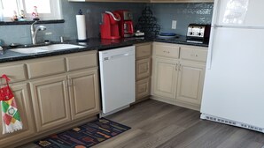 Una cocina con armarios de madera, lavavajillas, cafetera y tostadora.