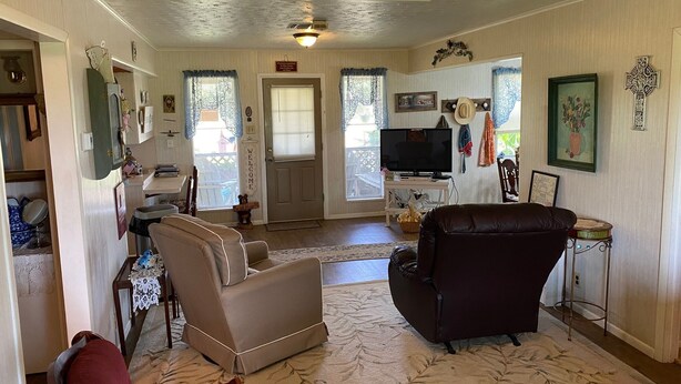 A living room with a television, two sofas, a coffee table, and a fireplace.