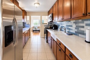 A modern kitchen with stainless steel appliances, wooden cabinets, and a tiled backsplash. - 2BR 1BA Condo in Roosevelt Row Arts District (Phoenix)