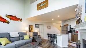 Una sala de estar moderna con un sofá gris, una mesa de centro y una chimenea.