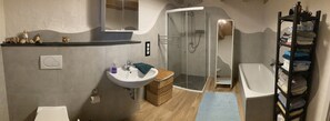 Bathtub, hair dryer, slippers, towels
