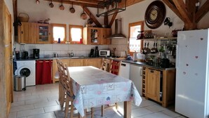 A kitchen with wooden cabinets, a dining table, and a refrigerator.