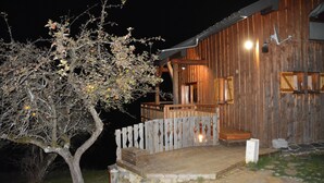 A wooden cabin with a wooden deck and a fenced porch.