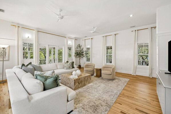 A spacious living room with a sectional sofa, a coffee table, and a TV stand.