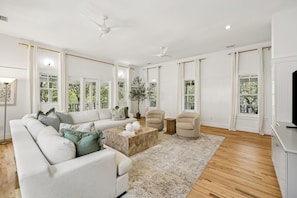A spacious living room with a sectional sofa, a coffee table, and a TV stand. - PRIVATE BEACH/POOL ACCESS -Minutes to the beach- Charming-4 Bikes Included (Rosemary Beach)