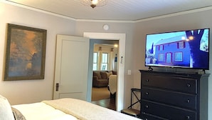 A bedroom with a bed, a dresser, a television, and a painting on the wall. - Lake Lanier, Fire Pit, Fishing, Boating, Short Walk To Lake, Bring Your Boat! (Gainesville)