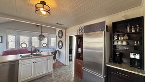A kitchen with a central island, a refrigerator, and a built-in coffee maker shelf. - Lake Lanier, Fire Pit, Fishing, Boating, Short Walk To Lake, Bring Your Boat! (Gainesville)