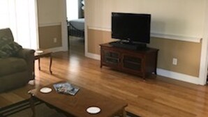 A living room with a sofa, coffee table, TV, and a ceiling fan. - A small piece of South Carolina Heaven (Myrtle Beach)