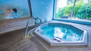 Ein Whirlpool mit Metallleiter, einer Holzbank und einem Wandgemälde.