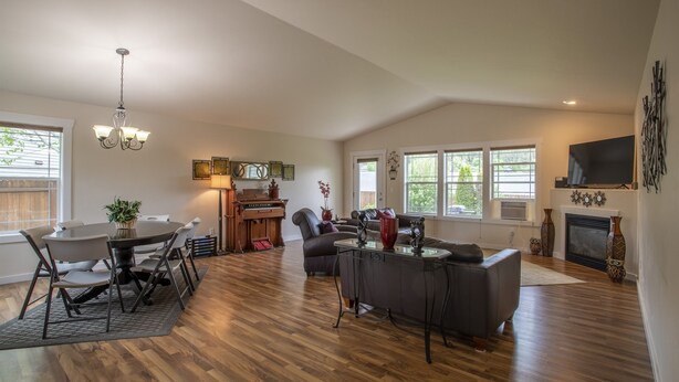 A spacious living room with a piano, a fireplace, and a large TV.