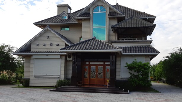 A two-story house with a prominent front entrance, a large window, and a tiled roof. - Annong RIver Homestay (Dongshan)