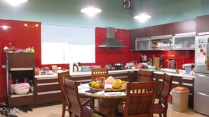A kitchen with a dining table, chairs, and various kitchen appliances. - Annong RIver Homestay (Dongshan)