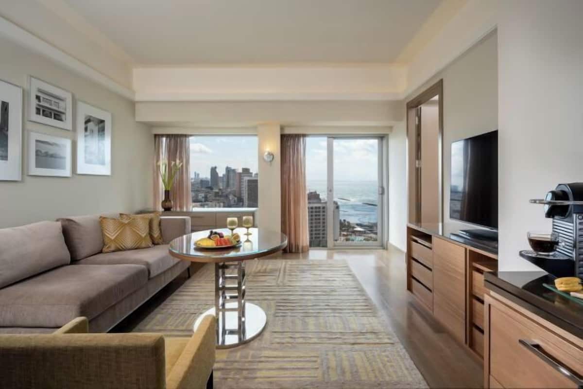 Een moderne hotelkamer met een bank, eettafel en een televisie.