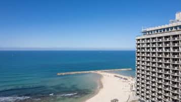 A high-rise hotel with a view of the ocean and beach.