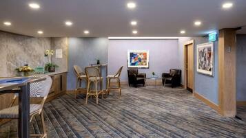 Vestíbulo de hotel con recepción, zona de estar y suelo alfombrado.